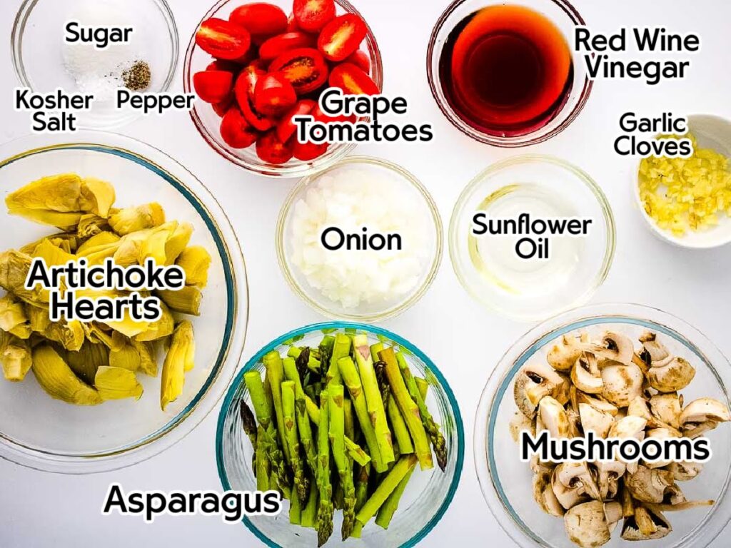 Ingredients to make cold summer vegetable salad with each labeled with the ingredient name.