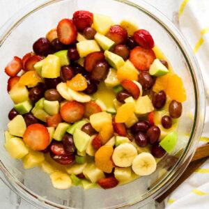 A glass bowl of prepared fresh and canned fruit salad.