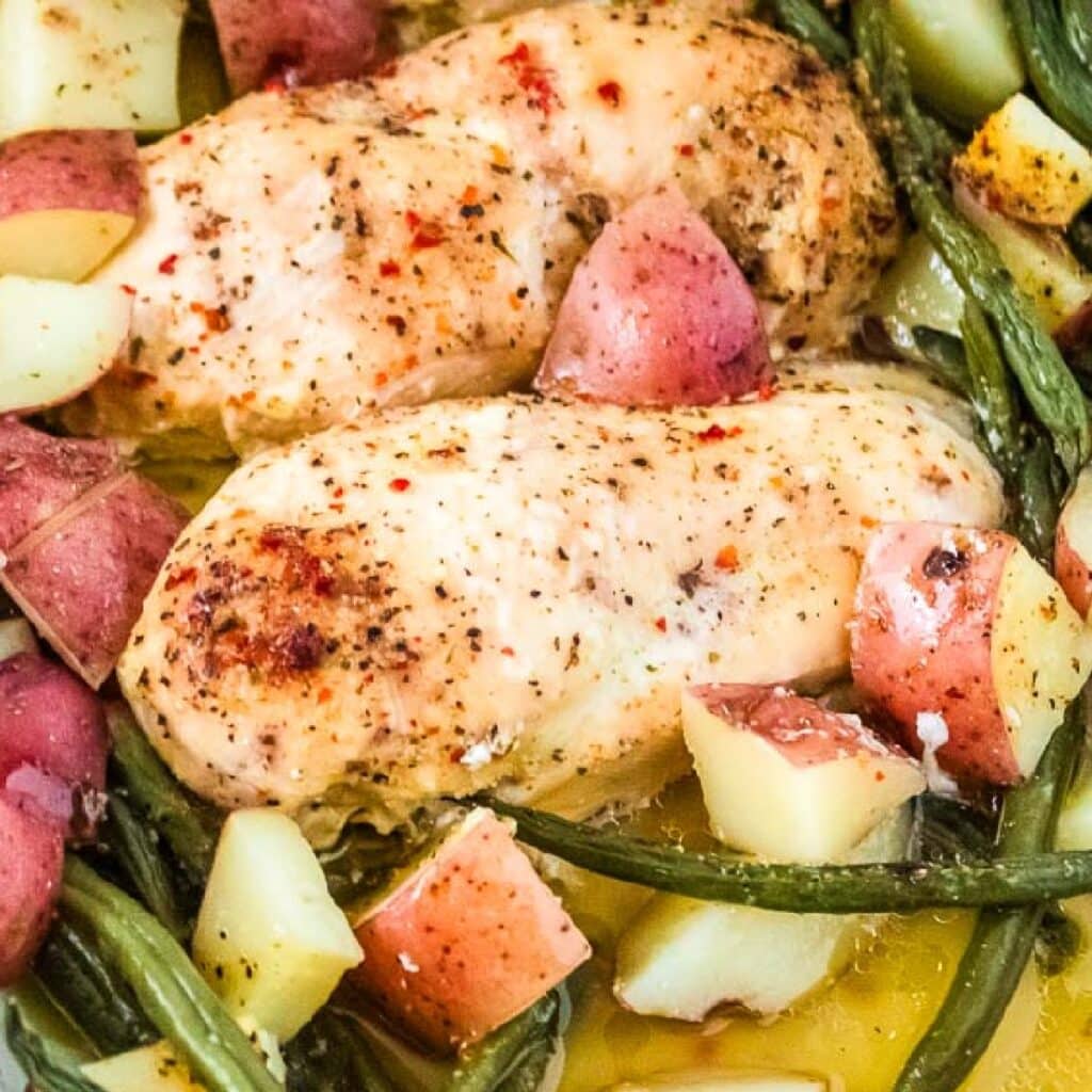 Closeup view of chicken potato green bean bake with butter and Italian seasonings.