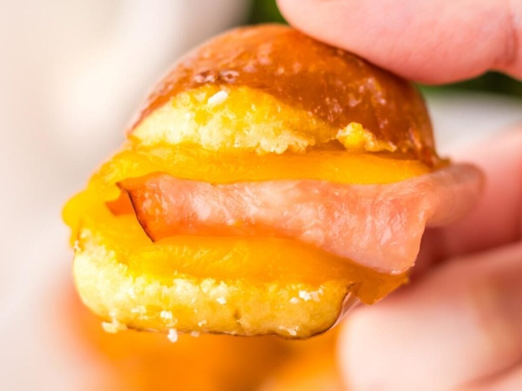 Closeup view of a single hot honey, ham and cheese pretzel bite fresh from the oven.