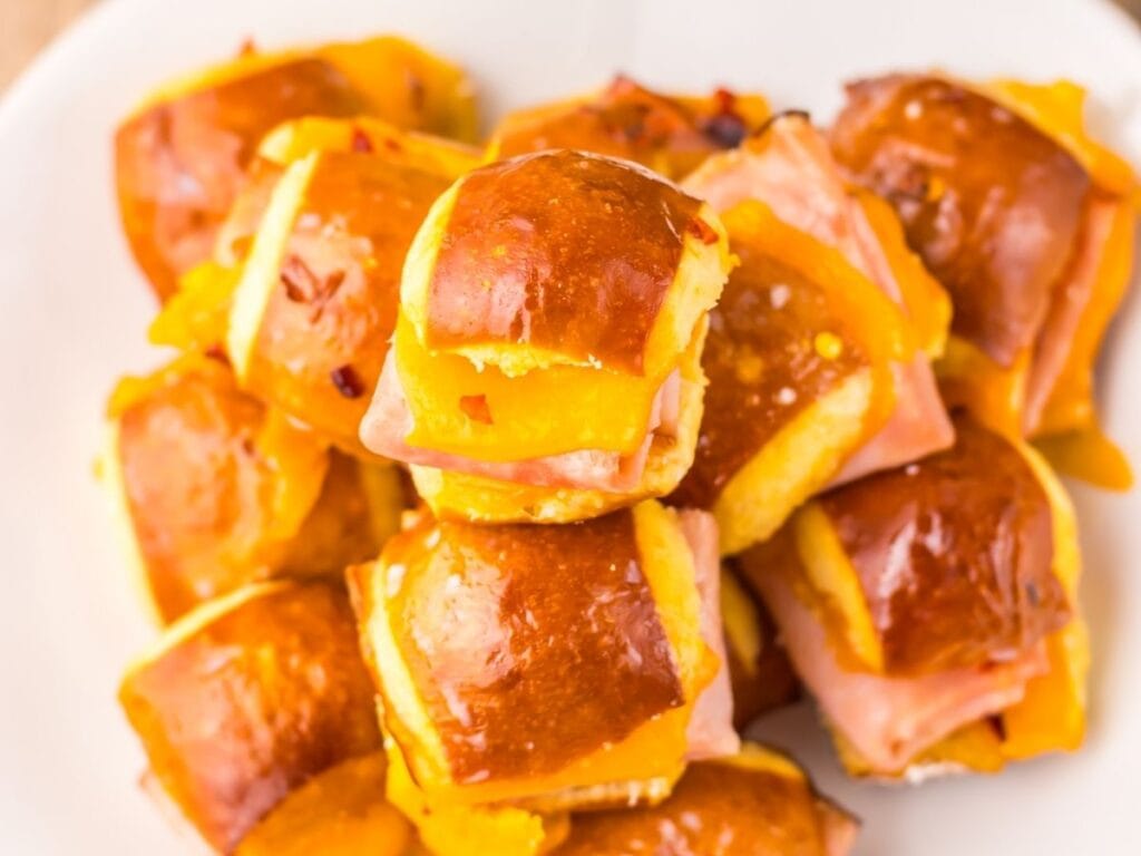 Overhead view of a stack pretzel bite sliders with ham and cheese.