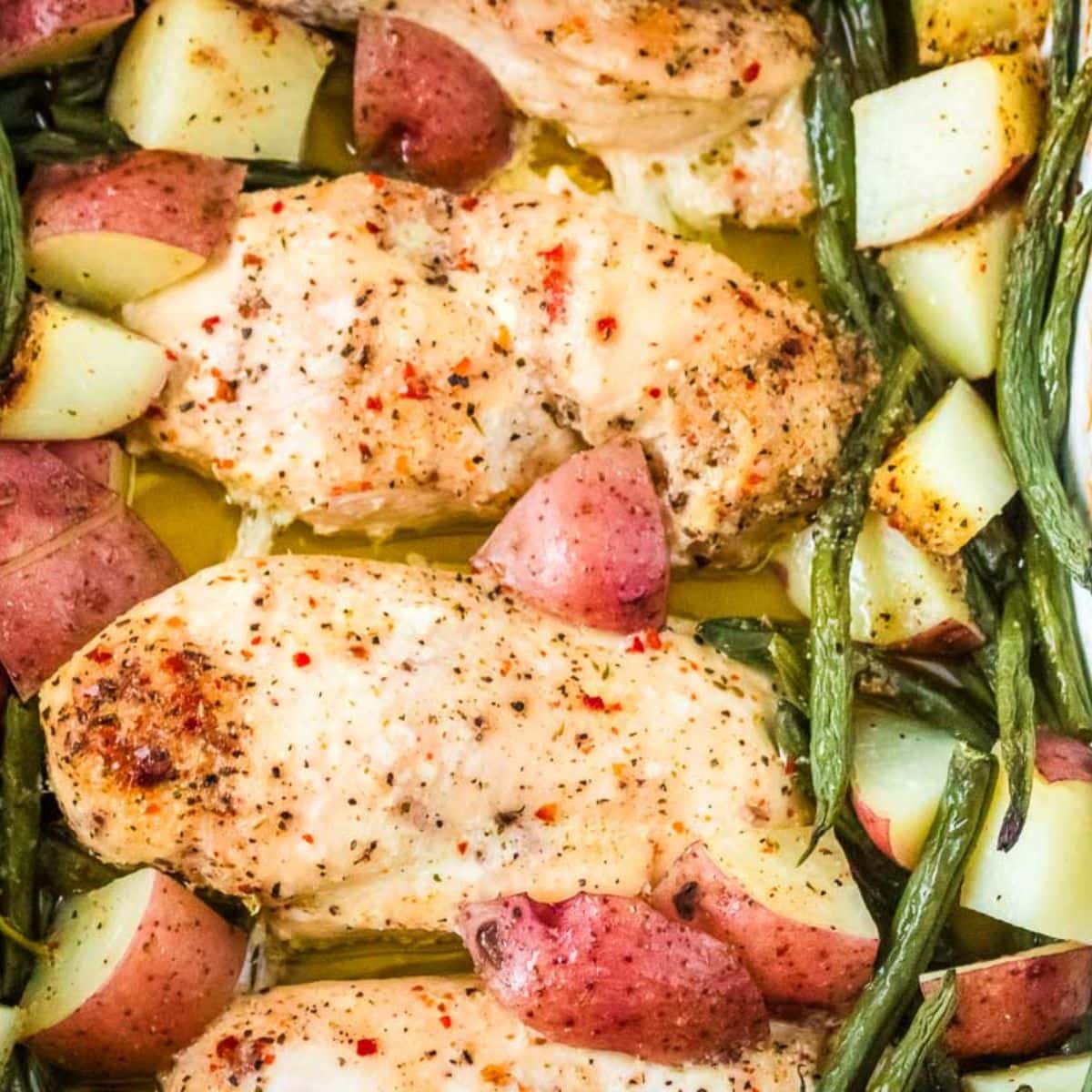 Closeup view of one pan chicken potato green bean bake with butter and Italian seasonings.