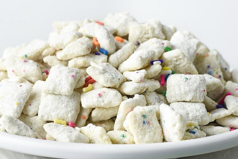 Front view of a bowl of cake batter puppy chow with cake mix.