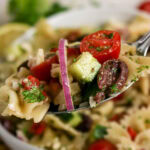 Close up view of a forkful of the best Mediterranean pasta salad.