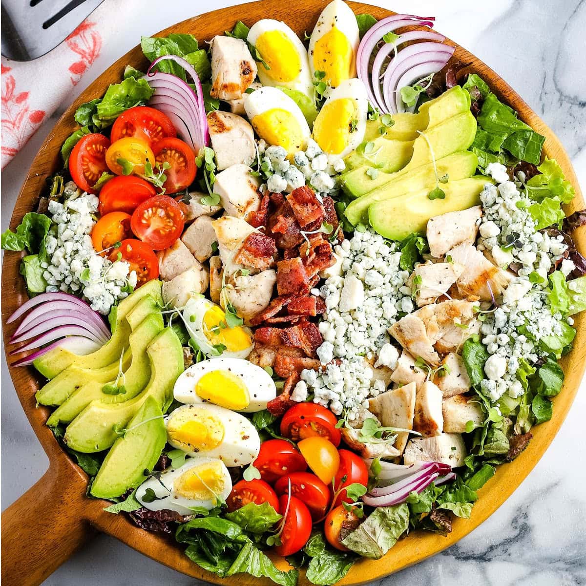 Overhead view of Chicken Cobb Salad in a wooden serving bowl.