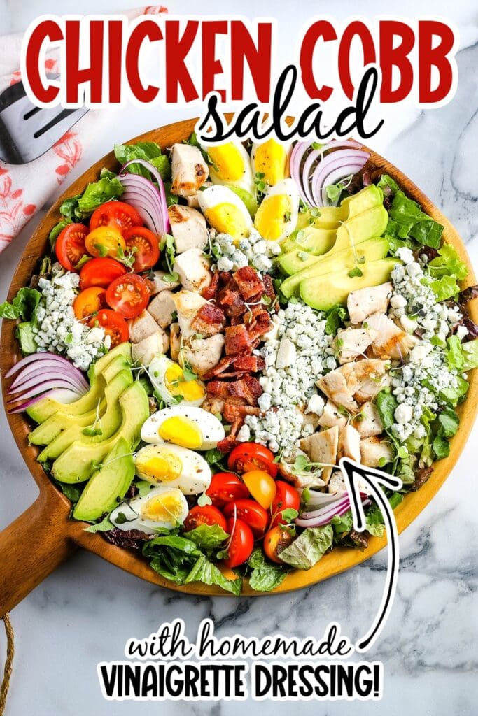Wooden bowl of Classic Cobb Salad with Chicken with dressing with graphic overlay.