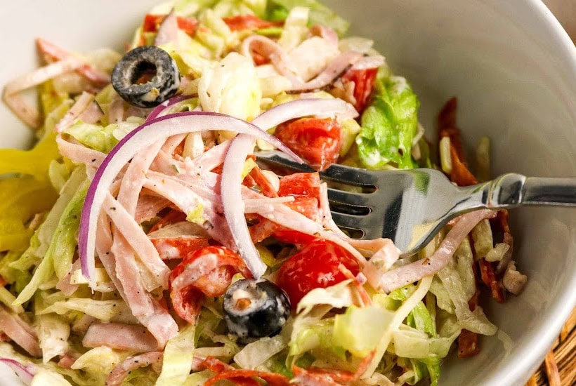 Fork digging into a bowl of Italian sub salad.