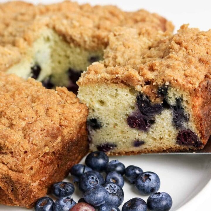 Close up of a slice of sour cream blueberry coffee cake being removed from the pan.