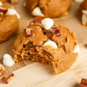 A Cake Mix Pumpkin Spice Cookie with a bite removed and surrounded by more cookies.